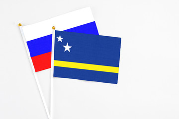 Curacao and Russia stick flags on white background. High quality fabric, miniature national flag. Peaceful global concept.White floor for copy space.