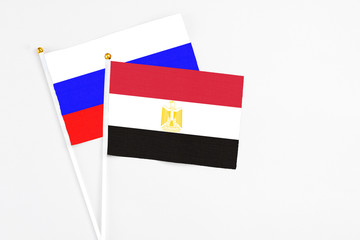 Egypt and Russia stick flags on white background. High quality fabric, miniature national flag. Peaceful global concept.White floor for copy space.