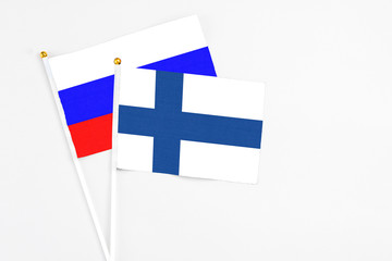 Obraz premium Finland and Russia stick flags on white background. High quality fabric, miniature national flag. Peaceful global concept.White floor for copy space.