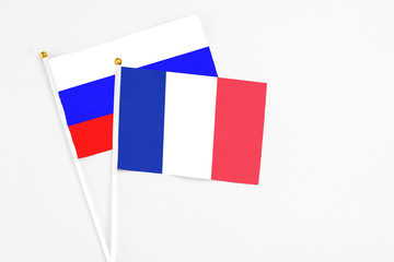 France and Russia stick flags on white background. High quality fabric, miniature national flag. Peaceful global concept.White floor for copy space.