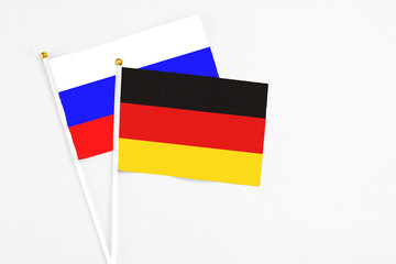 Germany and Russia stick flags on white background. High quality fabric, miniature national flag. Peaceful global concept.White floor for copy space.