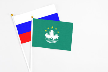 Macao and Russia stick flags on white background. High quality fabric, miniature national flag. Peaceful global concept.White floor for copy space.