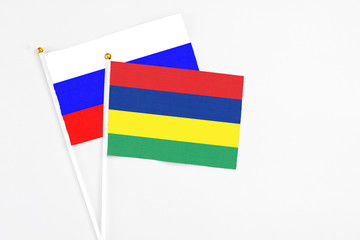Mauritius and Russia stick flags on white background. High quality fabric, miniature national flag. Peaceful global concept.White floor for copy space.