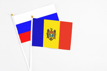 Moldova and Russia stick flags on white background. High quality fabric, miniature national flag. Peaceful global concept.White floor for copy space.