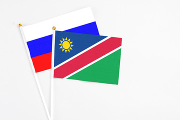 Namibia and Russia stick flags on white background. High quality fabric, miniature national flag. Peaceful global concept.White floor for copy space.