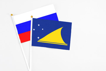 Tokelau and Russia stick flags on white background. High quality fabric, miniature national flag. Peaceful global concept.White floor for copy space.