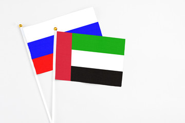 United Arab Emirates and Russia stick flags on white background. High quality fabric, miniature national flag. Peaceful global concept.White floor for copy space.