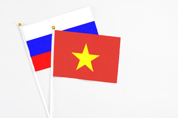 Vietnam and Russia stick flags on white background. High quality fabric, miniature national flag. Peaceful global concept.White floor for copy space.