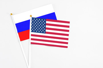 United States and Russia stick flags on white background. High quality fabric, miniature national flag. Peaceful global concept.White floor for copy space.