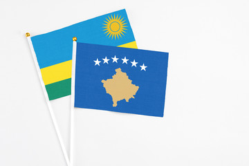 Kosovo and Rwanda stick flags on white background. High quality fabric, miniature national flag. Peaceful global concept.White floor for copy space.