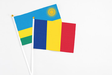 Romania and Rwanda stick flags on white background. High quality fabric, miniature national flag. Peaceful global concept.White floor for copy space.