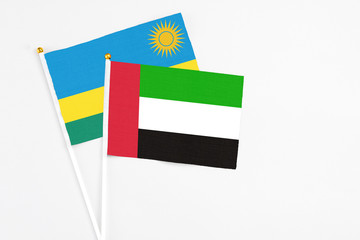 United Arab Emirates and Rwanda stick flags on white background. High quality fabric, miniature national flag. Peaceful global concept.White floor for copy space.