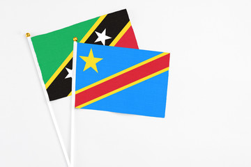 Congo and Saint Kitts And Nevis stick flags on white background. High quality fabric, miniature national flag. Peaceful global concept.White floor for copy space.