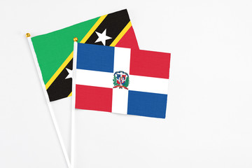Dominican Republic and Saint Kitts And Nevis stick flags on white background. High quality fabric, miniature national flag. Peaceful global concept.White floor for copy space.