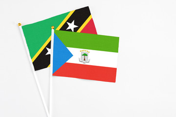Equatorial Guinea and Saint Kitts And Nevis stick flags on white background. High quality fabric, miniature national flag. Peaceful global concept.White floor for copy space.
