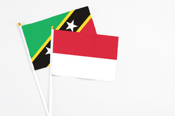 Indonesia and Saint Kitts And Nevis stick flags on white background. High quality fabric, miniature national flag. Peaceful global concept.White floor for copy space.