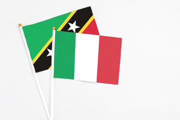 Italy and Saint Kitts And Nevis stick flags on white background. High quality fabric, miniature national flag. Peaceful global concept.White floor for copy space.