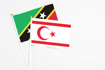 Northern Cyprus and Saint Kitts And Nevis stick flags on white background. High quality fabric, miniature national flag. Peaceful global concept.White floor for copy space.