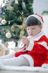 Merry christmas happy little child in santa red hat with beautifully decorated christmas tree holidays in home, christmas concept