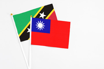 Taiwan and Saint Kitts And Nevis stick flags on white background. High quality fabric, miniature national flag. Peaceful global concept.White floor for copy space.