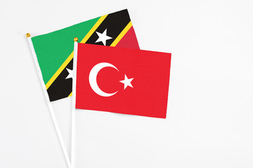 Turkey and Saint Kitts And Nevis stick flags on white background. High quality fabric, miniature national flag. Peaceful global concept.White floor for copy space.