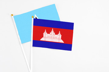 Cambodia and Saint Lucia stick flags on white background. High quality fabric, miniature national flag. Peaceful global concept.White floor for copy space.