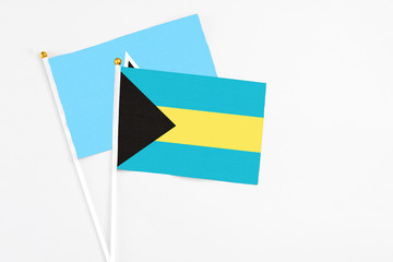 Bahamas and Saint Lucia stick flags on white background. High quality fabric, miniature national flag. Peaceful global concept.White floor for copy space.