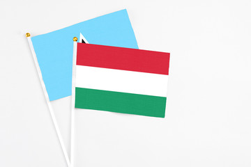Hungary and Saint Lucia stick flags on white background. High quality fabric, miniature national flag. Peaceful global concept.White floor for copy space.
