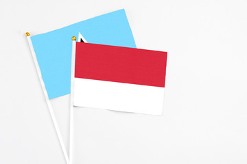 Monaco and Saint Lucia stick flags on white background. High quality fabric, miniature national flag. Peaceful global concept.White floor for copy space.