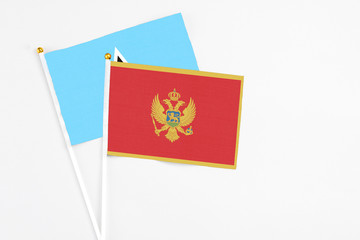 Montenegro and Saint Lucia stick flags on white background. High quality fabric, miniature national flag. Peaceful global concept.White floor for copy space.