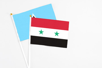 Syria and Saint Lucia stick flags on white background. High quality fabric, miniature national flag. Peaceful global concept.White floor for copy space.