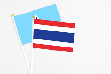 Thailand and Saint Lucia stick flags on white background. High quality fabric, miniature national flag. Peaceful global concept.White floor for copy space.