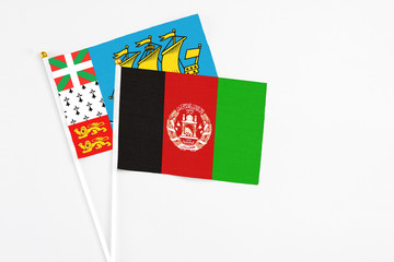 Afghanistan and Saint Pierre And Miquelon stick flags on white background. High quality fabric, miniature national flag. Peaceful global concept.White floor for copy space.