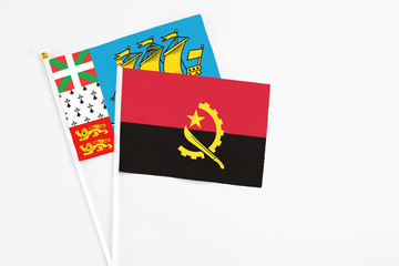 Angola and Saint Pierre And Miquelon stick flags on white background. High quality fabric, miniature national flag. Peaceful global concept.White floor for copy space.