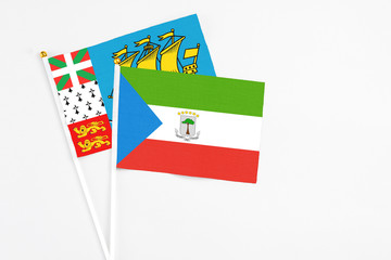 Equatorial Guinea and Saint Pierre And Miquelon stick flags on white background. High quality fabric, miniature national flag. Peaceful global concept.White floor for copy space.