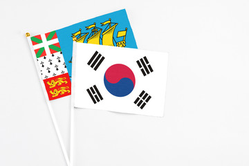 South Korea and Saint Pierre And Miquelon stick flags on white background. High quality fabric, miniature national flag. Peaceful global concept.White floor for copy space.