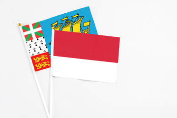 Monaco and Saint Pierre And Miquelon stick flags on white background. High quality fabric, miniature national flag. Peaceful global concept.White floor for copy space.