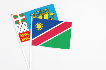 Namibia and Saint Pierre And Miquelon stick flags on white background. High quality fabric, miniature national flag. Peaceful global concept.White floor for copy space.