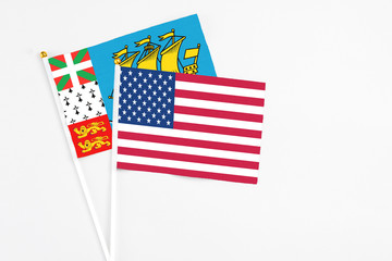 United States and Saint Pierre And Miquelon stick flags on white background. High quality fabric, miniature national flag. Peaceful global concept.White floor for copy space.