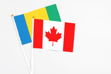 Canada and Saint Vincent And The Grenadines stick flags on white background. High quality fabric, miniature national flag. Peaceful global concept.White floor for copy space.