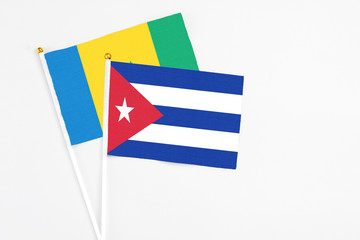 Obraz premium Cuba and Saint Vincent And The Grenadines stick flags on white background. High quality fabric, miniature national flag. Peaceful global concept.White floor for copy space.
