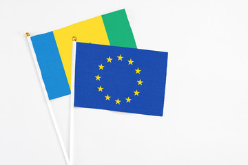 European Union and Saint Vincent And The Grenadines stick flags on white background. High quality fabric, miniature national flag. Peaceful global concept.White floor for copy space.