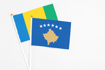 Kosovo and Saint Vincent And The Grenadines stick flags on white background. High quality fabric, miniature national flag. Peaceful global concept.White floor for copy space.