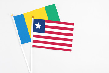 Liberia and Saint Vincent And The Grenadines stick flags on white background. High quality fabric, miniature national flag. Peaceful global concept.White floor for copy space.