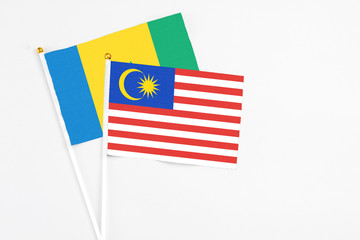 Malaysia and Saint Vincent And The Grenadines stick flags on white background. High quality fabric, miniature national flag. Peaceful global concept.White floor for copy space.