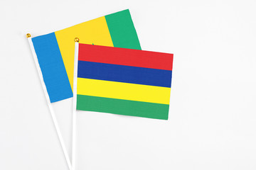 Mauritius and Saint Vincent And The Grenadines stick flags on white background. High quality fabric, miniature national flag. Peaceful global concept.White floor for copy space.