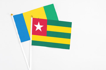 Togo and Saint Vincent And The Grenadines stick flags on white background. High quality fabric, miniature national flag. Peaceful global concept.White floor for copy space.
