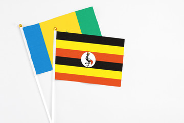 Uganda and Saint Vincent And The Grenadines stick flags on white background. High quality fabric,...
