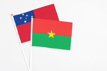 Burkina Faso and Samoa stick flags on white background. High quality fabric, miniature national flag. Peaceful global concept.White floor for copy space.