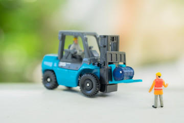Miniature People : Worker talked with engineer who driving the forklift with copy space on sunset background, industrial concept, used as wallpaper
